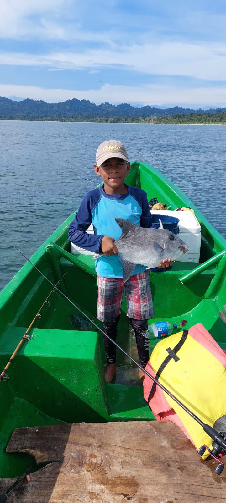 Young fisher holding a fresh catch on the Caribbean Sea